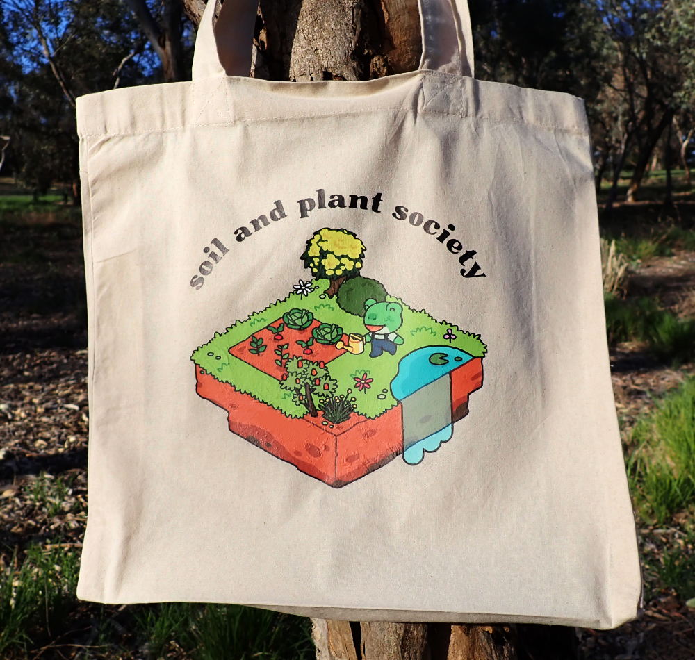 A tote bag for the Soil and Plant Society with an illustration of a frog on a floating island garden